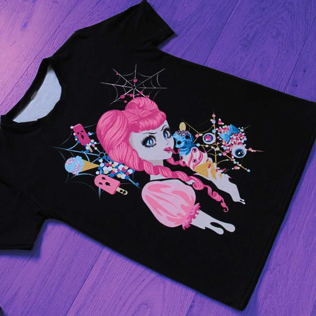 Alt text for an alternative view: “A stylish presentation of the ‘Demon Kawaii Ice Cream Pastel Goth’ t-shirt unfolds on the floor. The pastel goth, kawaii, yami kawaii, and shoujo manga influences shine in this carefully arranged display, featuring an enchanting design of a demon relishing an ice cream amidst a dreamy pastel ambiance.